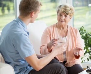 Carer giving elderly lady medication