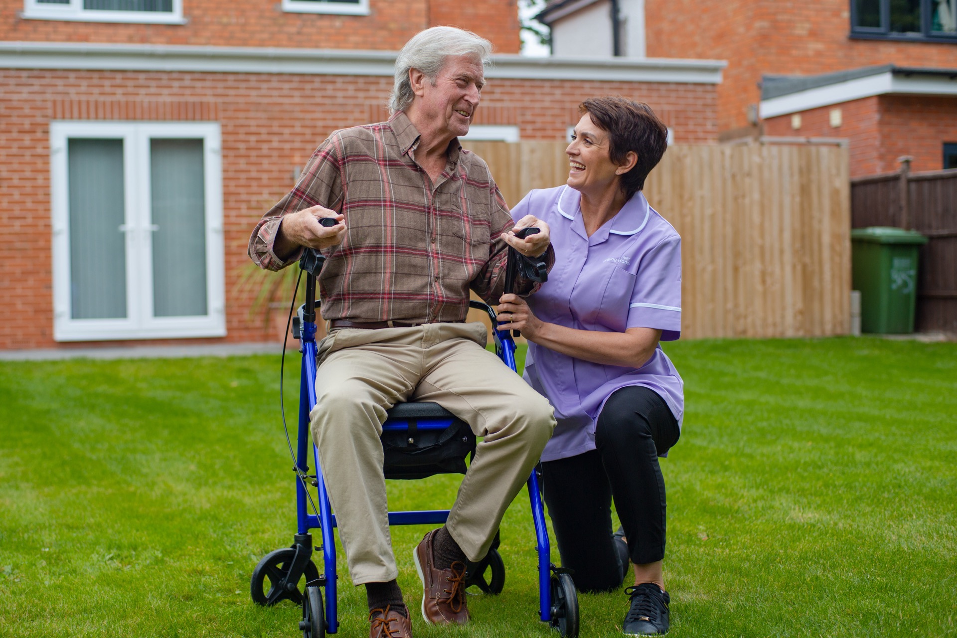 a women working in respite care helping an elderly man to walk