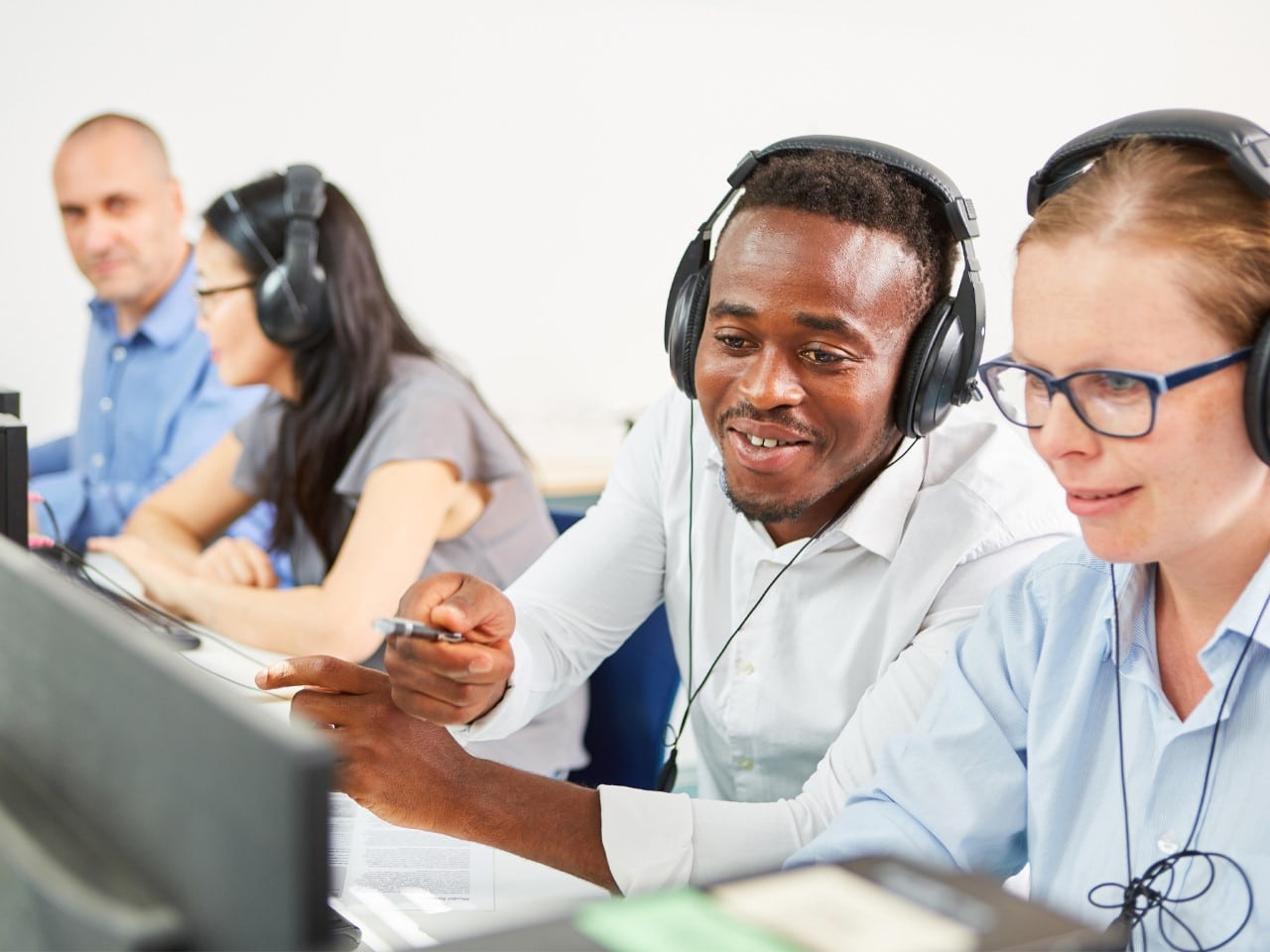 Young male looking at screen with young female